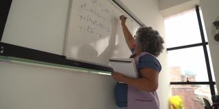 老师在黑板上写字，戴着口罩