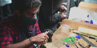 中东男学生在大学工作台擦拭珠宝