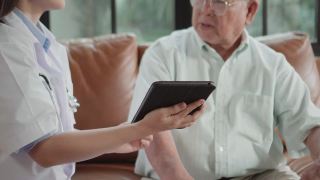 护士拿着药片和老年人谈论药物。视频素材模板下载