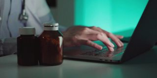 医生使用笔记本电脑工作和药丸药瓶