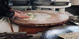 土耳其厨师制作gozleme:在土耳其一家酒店的餐厅厨房把它封好，放在热的煎锅上。