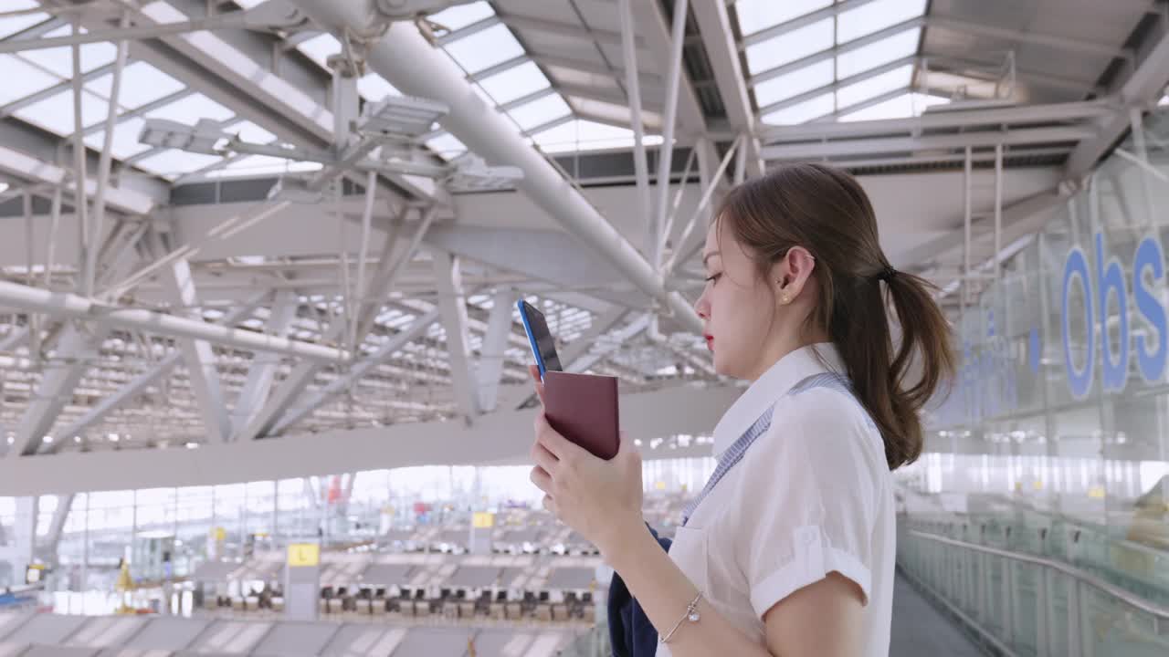 20-30岁的亚洲裔女性在新冠肺炎疫情下使用智能手机在机场旅行，新冠肺炎封锁和旅行重新开放后的新常态办公生活方式，