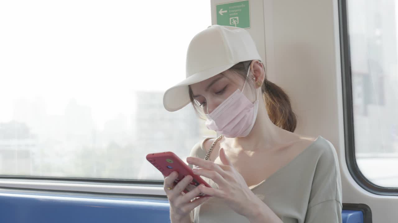 游客在乘坐巴士去机场时使用手机。