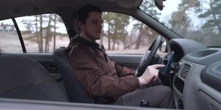 一名欧洲男子坐在驾驶室里使用智能手机
