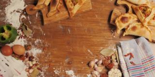 南美食物:脆炸肉馅肉馅卷饼，放在白色的托盘上，白色的木头背景上，配有厨房抹布