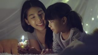 女儿和妈妈在她生日那天吹蜡烛视频素材模板下载
