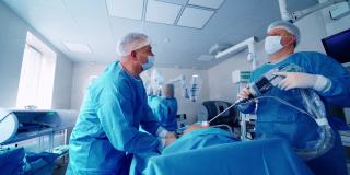医生在医院的手术室里使用机器人。机械臂是一种现代医疗设备，在现代手术室中进行手术。