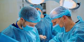 临床外科医生的团队合作。经验丰富的医生在现代手术室里用电子医疗工具进行手术。