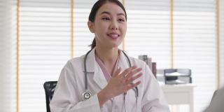 迷人的美丽年轻的亚洲医生女穿着白袍听诊器在肩上诊断与病人谈话提供帮助咨询，治疗或解释处方在办公室诊所。