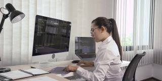 软件开发人员正在办公室的计算机上分析编写到程序中的代码。
