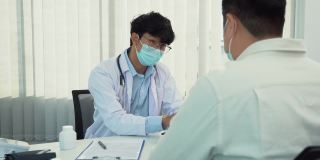医生正在解释在病毒爆发期间戴着口罩用药片治疗病人的方法。