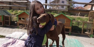 可爱的小女孩，在动物救助中心拥抱小狗