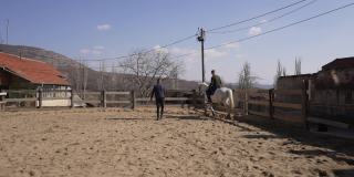 快乐的游客在动物救援中心学习如何骑马，同时志愿帮助他
