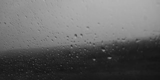 雨天旅行时，雨滴落在车窗上。坏天气的概念。