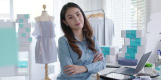 肖像年轻迷人的亚洲女企业主创业看相机工作开心用盒子在家准备包裹快递中小企业供应链，采购，全渠道电商在线概念。