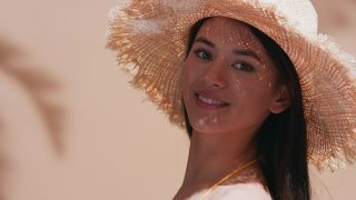 年轻的美模特戴着草帽，转身享受阳光视频素材模板下载