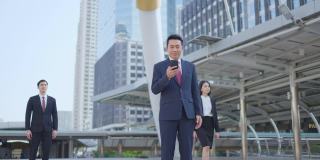 亚洲经理聪明的商人使用智能手机在城市。那人拿着电话，一边说话，一边微笑着站在户外。以电信和移动网络为经营理念。