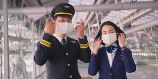 新冠肺炎疫情期间，飞行员和空乘人员戴口罩走在机场航站楼走向飞机，以预防新冠肺炎感染。航空运输的新常态生活理念。