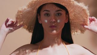 年轻的亚洲女子在脸颊上涂了防晒霜，她给了我一个飞吻视频素材模板下载