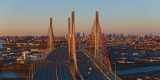 鸟瞰图科修斯科桥周围的威廉斯堡工业区，与曼哈顿的远景在背景，在清晨阳光明媚。航拍视频与加速宽轨道平移摄像机运动。