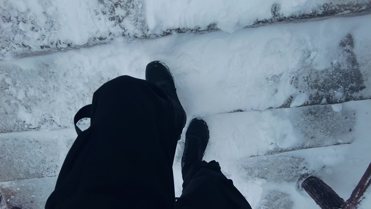 男人走在积雪的楼梯上