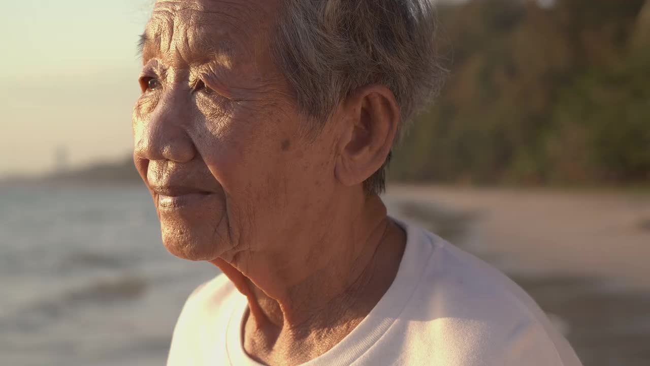 一位高级妇女在海上的肖像。她微笑着看着镜头。