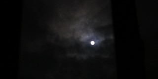 透过窗户看到满月。满月和云彩。