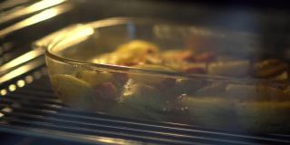 一盘肉和土豆放在烤箱里的玻璃碗里烤着