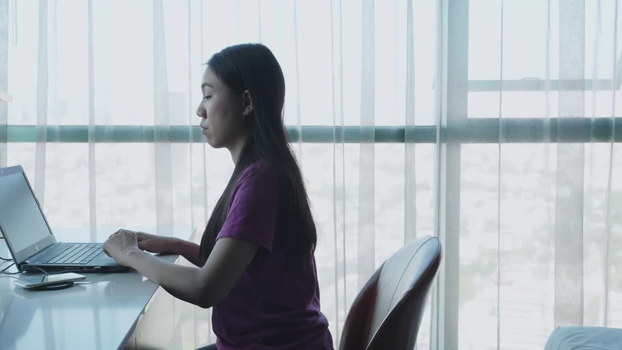 年轻女子在家办公用她的电脑和桌子