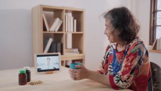 亚洲资深女性在远程医疗预约时与年轻医生进行虚拟考试，在家做护士视频素材模板下载