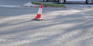 城市街道沥青路面上的交通锥警告司机由于道路施工和汽车通过的危险