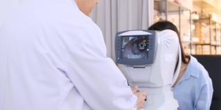 眼科医生用光学折射仪检查妇女的眼睛。