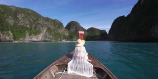 后视图亚洲妇女在热带岛屿乘船旅行，船在Kho Phi Phi Lee岛-泰国