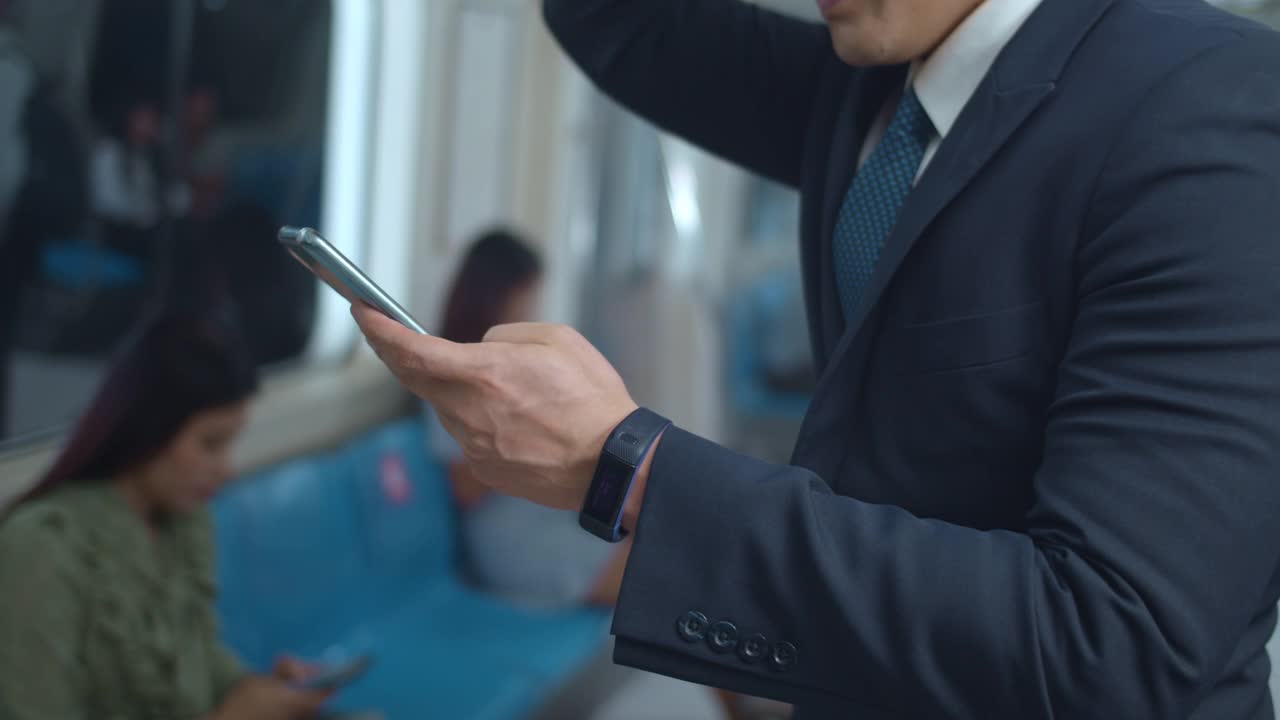 商人在乘坐地铁期间使用智能手机，特写