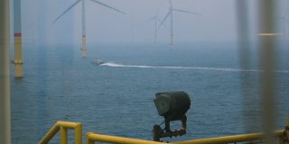 从帆船上看海上风力发电机-风力发电场真窗。在风力涡轮机之间航行的客船