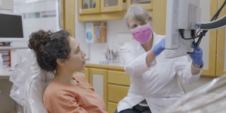 年轻的成年病人正在看她的牙医的x光照片