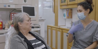 混血牙科保健师与年长的女病人交谈