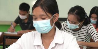 亚洲小学生戴上口罩预防病毒上课开始重开。