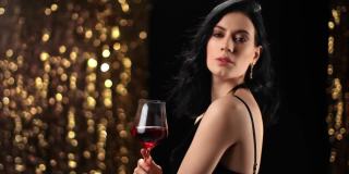 肖像时装女人与一杯红酒摆姿势在迪斯科派对。用RED摄像机拍摄4K