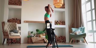 在线学习和直播女性博客用手机摄像头拍摄健身