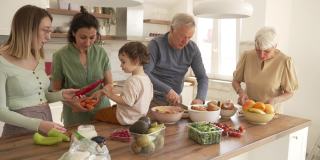 在他们的家庭早午餐期间，兴奋的蹒跚学步的孩子用一片黄瓜喂祖父母和他的阿姨