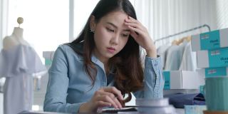 年轻有魅力的亚洲女企业主深思熟虑严重怀疑感到压力担心财务问题中小企业危机小企业挑战冲击在家里的办公室。