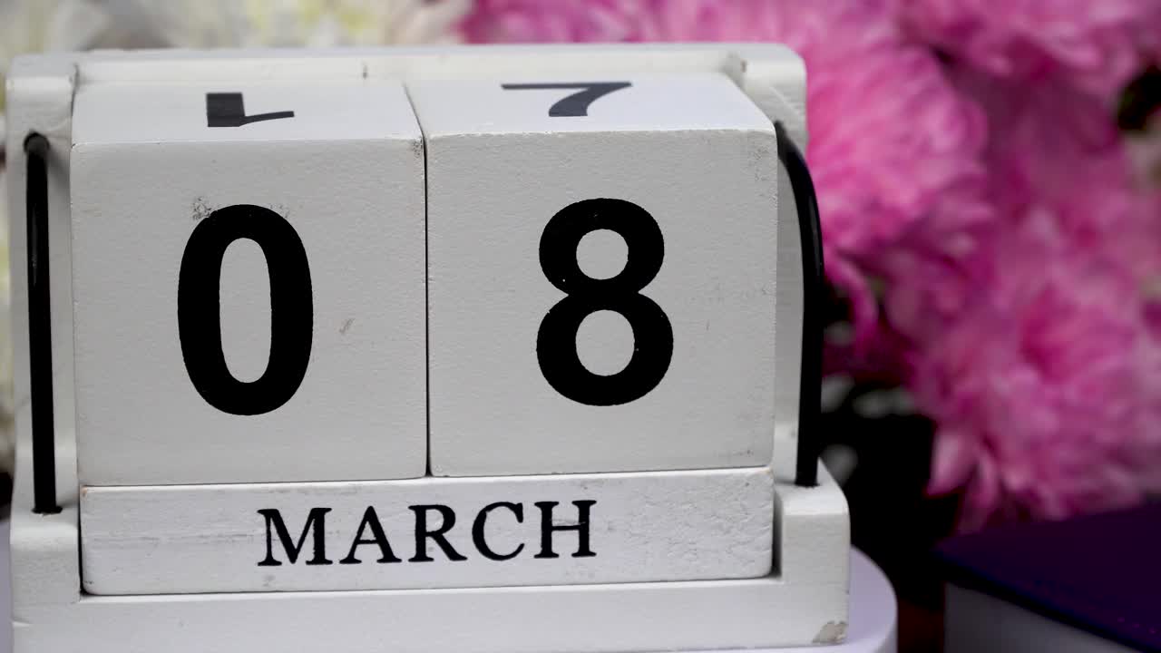 桌面日历上有3月8日的日期和一束美丽的鲜花。三八娇嫩菊花。手工木方与日期，月和日。为一天做计划。