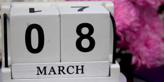 桌面日历上有3月8日的日期和一束美丽的鲜花。三八娇嫩菊花。手工木方与日期，月和日。为一天做计划。