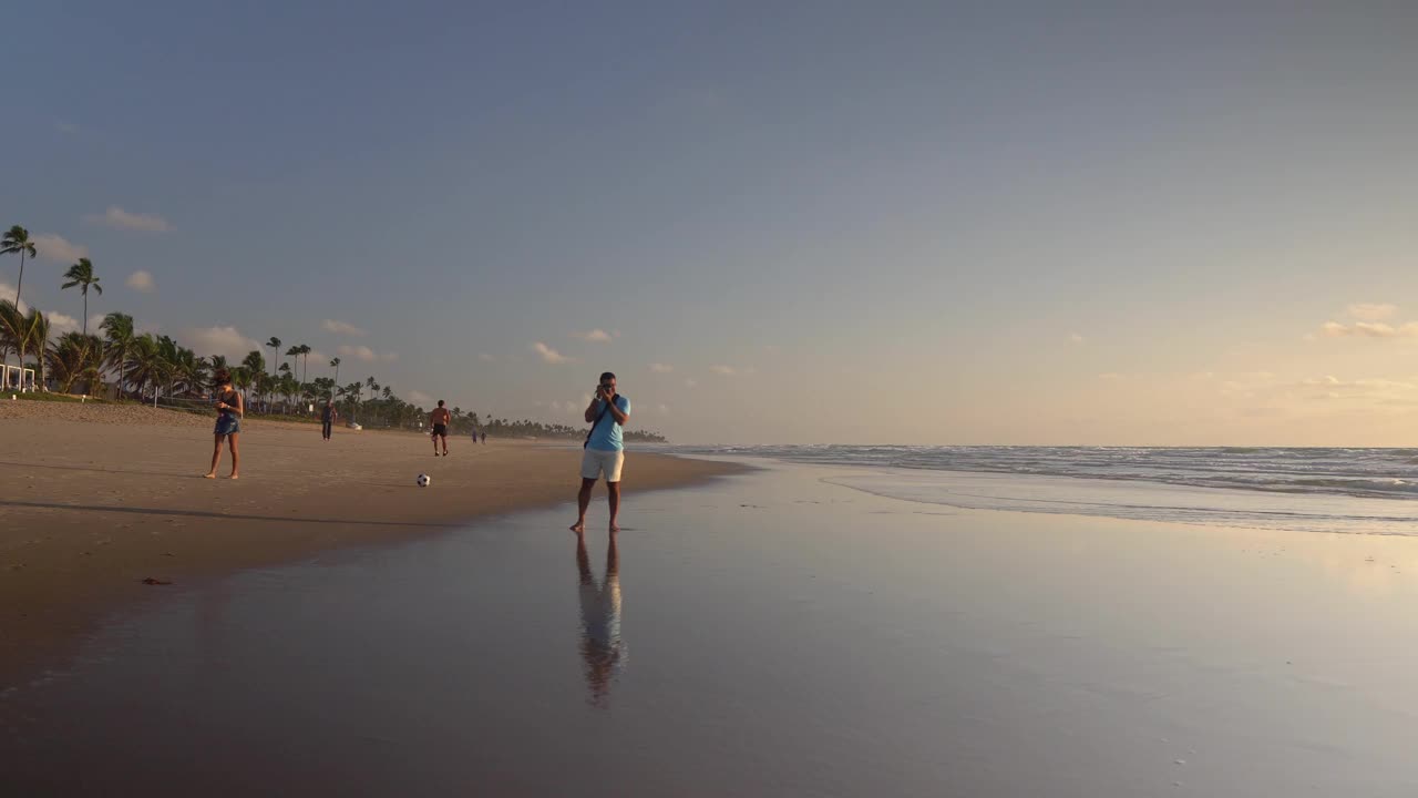 摄影师在日出时在海滩上拍照