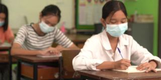 亚洲小学生戴上口罩预防病毒上课开始重开。