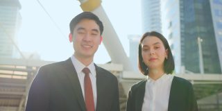 亚洲经理和美丽的秘书在城市公司办公室工作的肖像。商界人士自信满满，面带微笑。业务概念的职位申请和招聘。