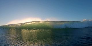 海浪在日出时散开。日出时，强烈的海浪冲击着摄像机