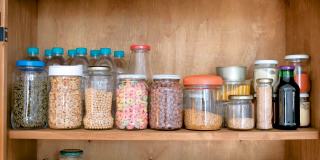 木制的食品储藏室堆满了散装产品的玻璃罐。