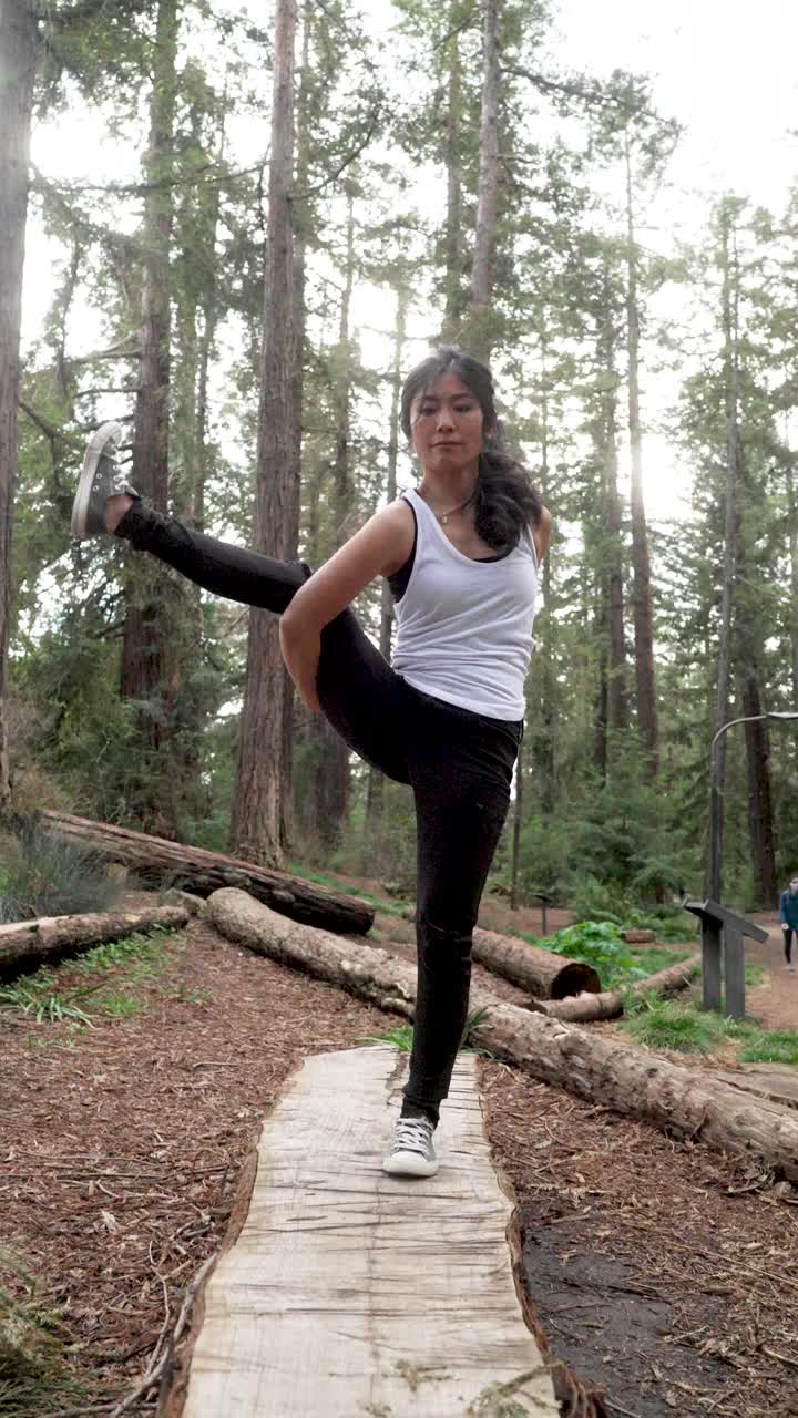 亚洲中年妇女在公园练习瑜伽